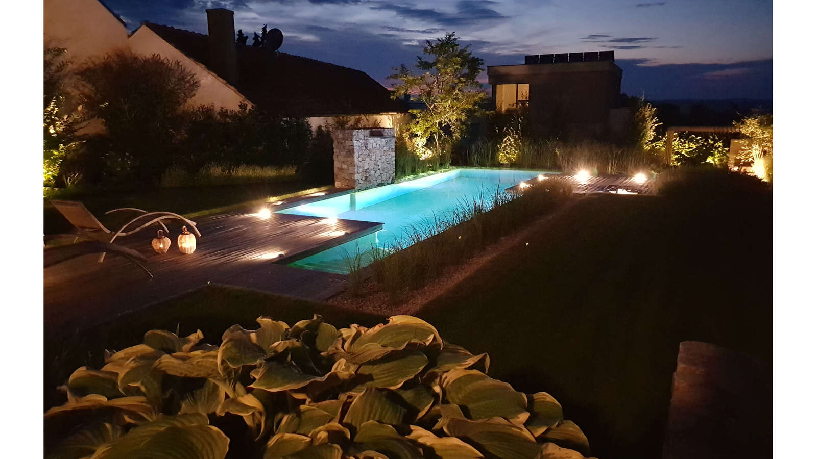 Abendstimmung in Garten mit beleuchtetem Pool